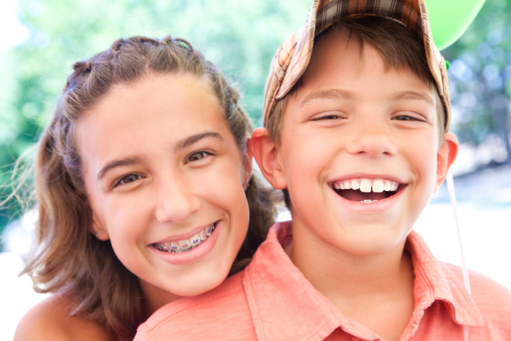 Brother and sister smiling and hugging